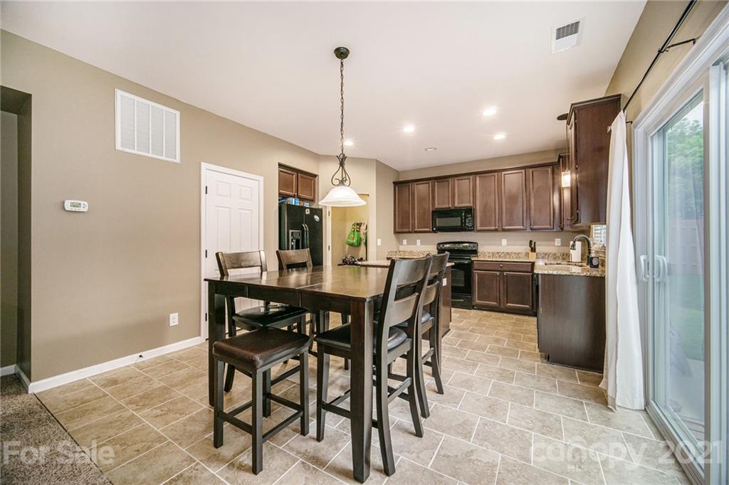 7678 West Berkeley Road Denver, NC 28037 - Photo 10 of 29 a kitchen with stainless steel appliances kitchen island granite countertop a table chairs and a refrigerator