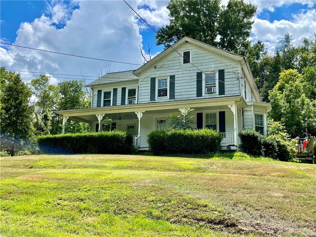 a front view of a house with swimming pool and green space