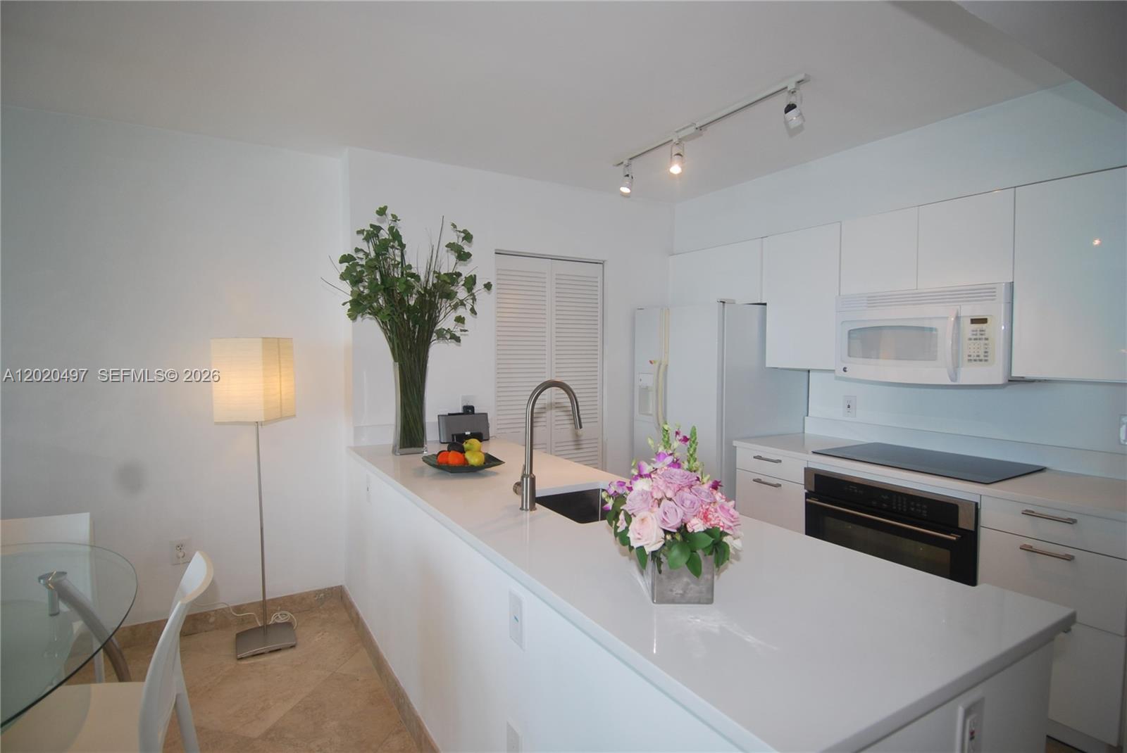 90 Alton Road, Unit 2708 Miami Beach, FL 33139 - Photo 3 of 10 a kitchen with a sink and cabinets
