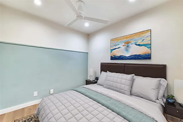 a bedroom with a bed and a painting on the wall