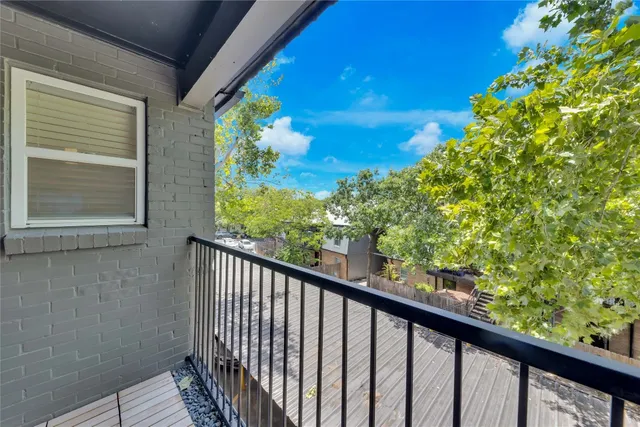 a view of a balcony with wooden floor and fence