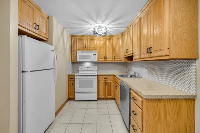 a kitchen with stainless steel appliances granite countertop a stove a sink dishwasher and cabinets with wooden floor