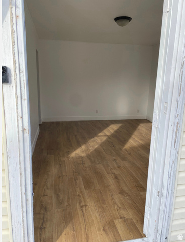230 North 2nd Street Tooele, UT 84074 - Photo 6 of 18 Interior room featuring wood-finish flooring, white painted walls, and a ceiling-mounted light fixture
