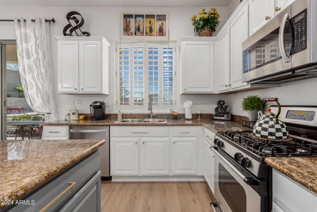 a kitchen with stainless steel appliances granite countertop a stove a sink and a microwave