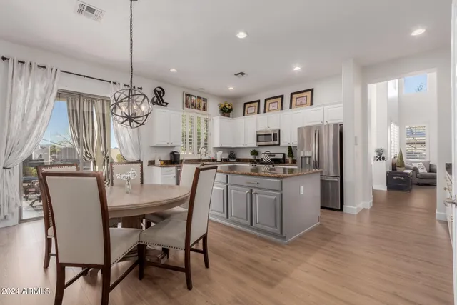 a kitchen with refrigerator and wooden floor