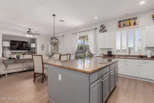 a kitchen with stainless steel appliances granite countertop a sink a stove and a wooden floors