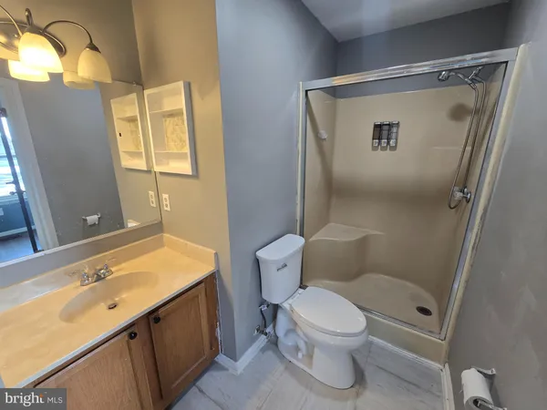 a bathroom with a granite countertop sink toilet and shower