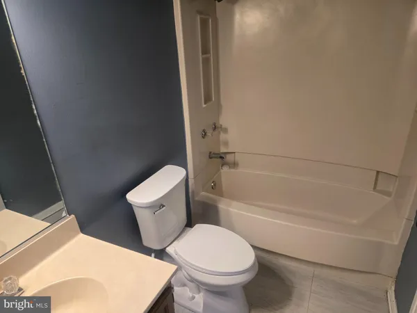 a white toilet sitting next to a bath tub