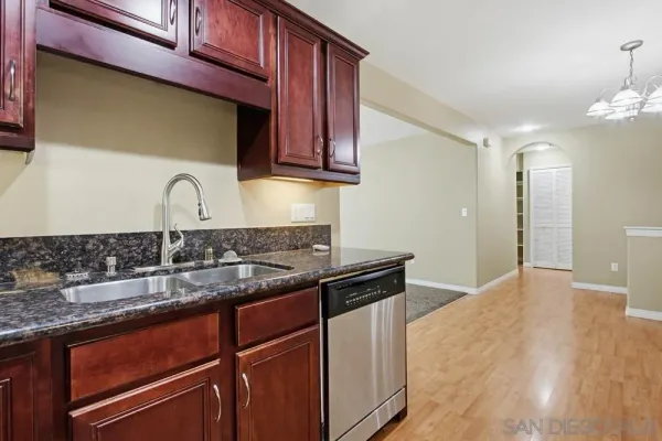 a kitchen with granite countertop a sink cabinets and wooden floor