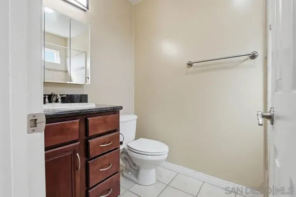 a bathroom with a granite countertop toilet sink and mirror