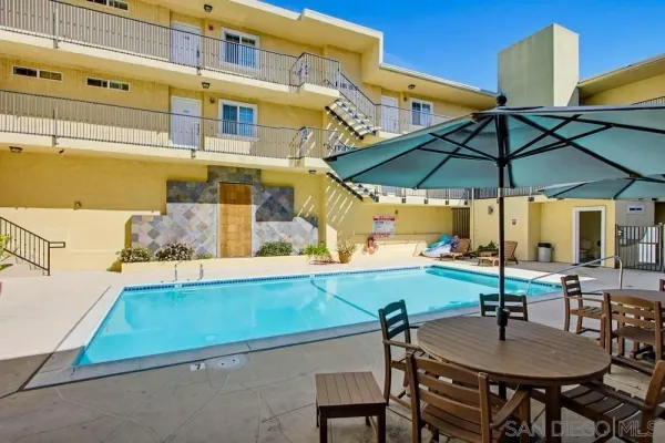 a view of a patio with a table and chairs under an umbrella