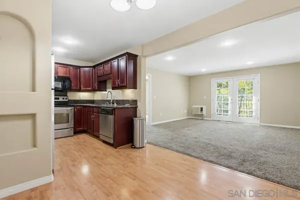 a kitchen with stainless steel appliances granite countertop a stove a sink dishwasher and a refrigerator