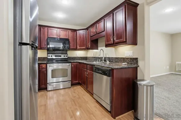 a kitchen with stainless steel appliances granite countertop a stove top oven a sink and dishwasher
