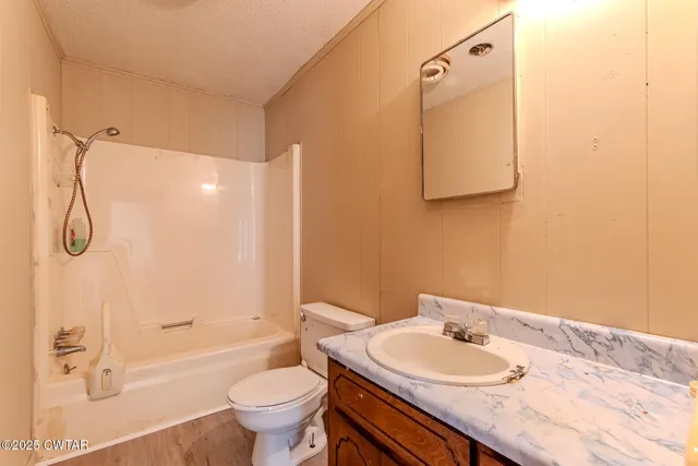 a bathroom with a granite countertop sink toilet a mirror and shower