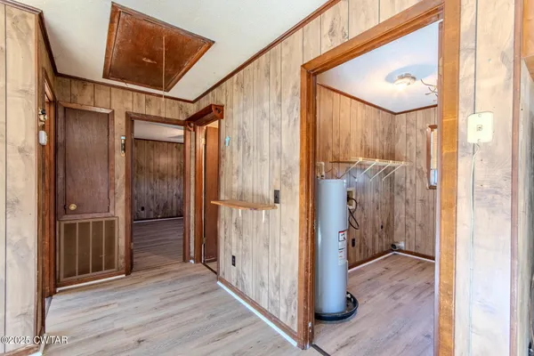 a view of a hallway with wooden floor and entryway