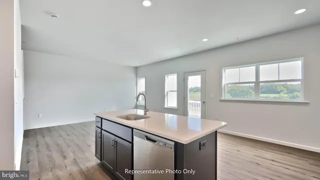 a kitchen with a sink cabinets and wooden floor