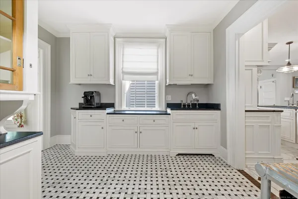 a kitchen with a refrigerator a stove and white cabinets