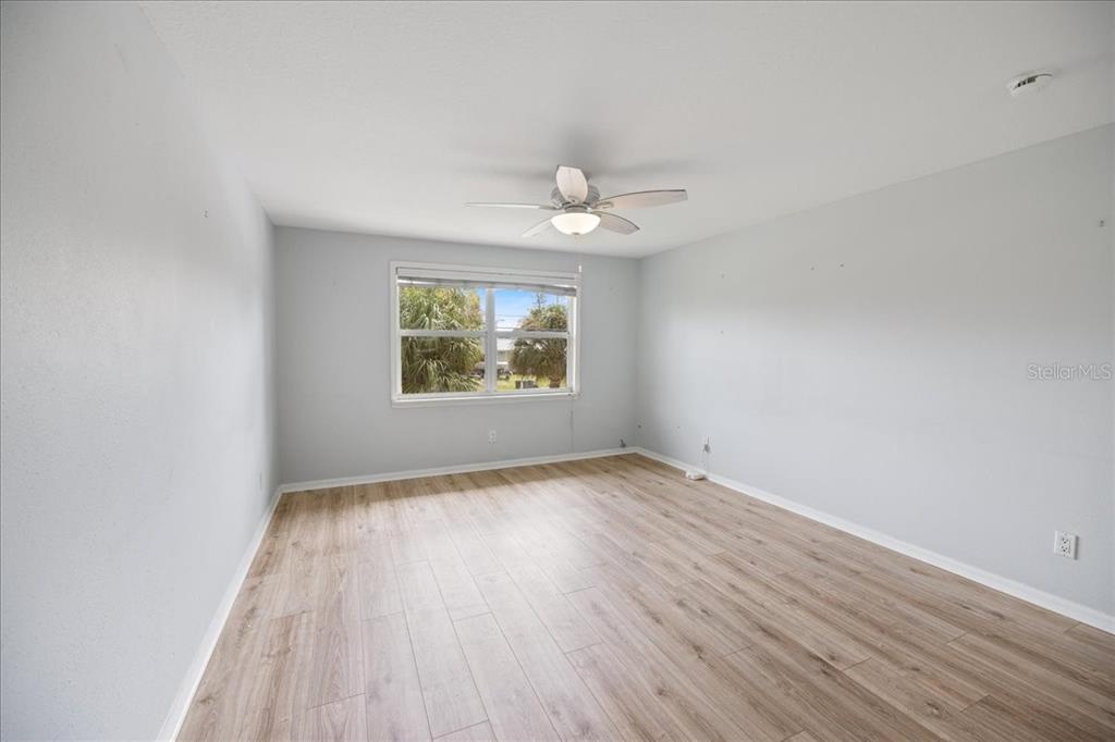 307 Winfield Way Nokomis, FL 34275 - Photo 23 of 58 an empty room with wooden floor chandelier fan and windows