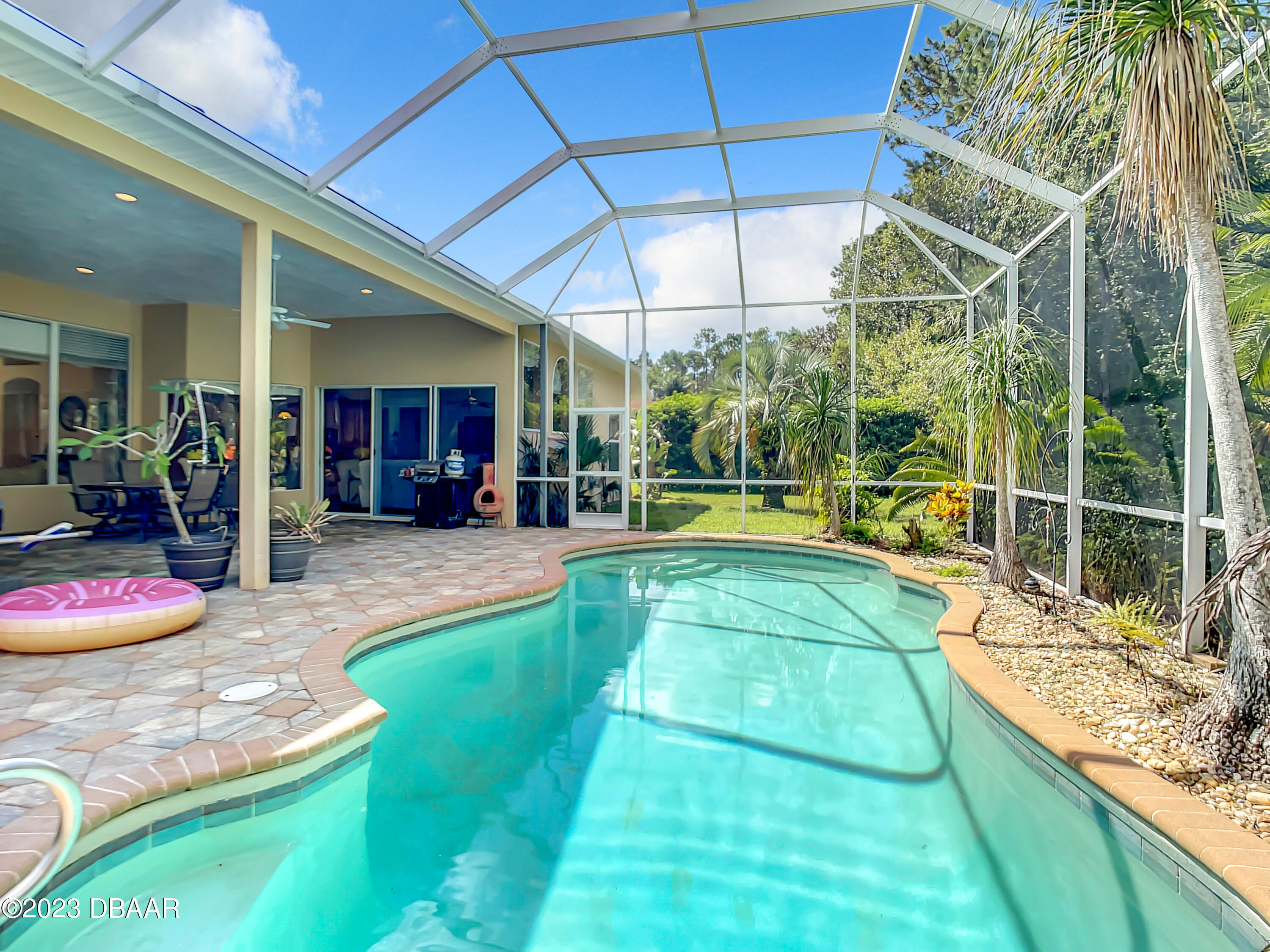 123 Deep Woods Way Ormond Beach, FL 32174 - Photo 53 of 66 a view of a backyard with table and chairs under an umbrella