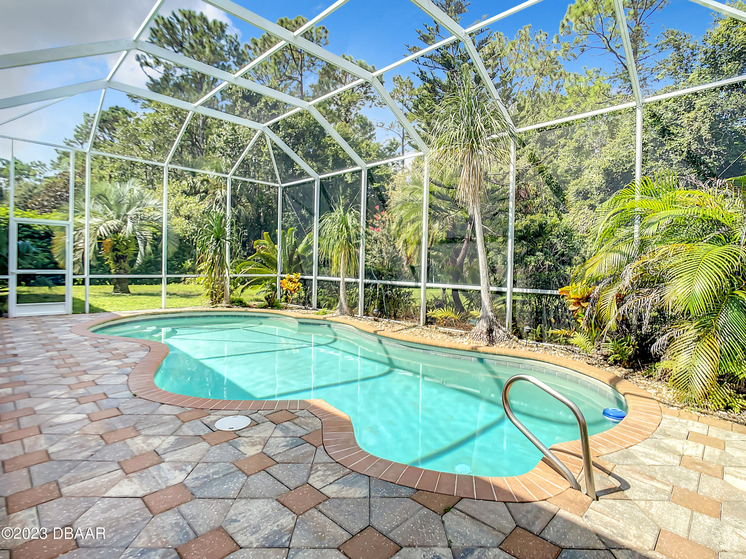 123 Deep Woods Way Ormond Beach, FL 32174 - Photo 54 of 66 a view of a swimming pool with a lawn chairs and a small yard