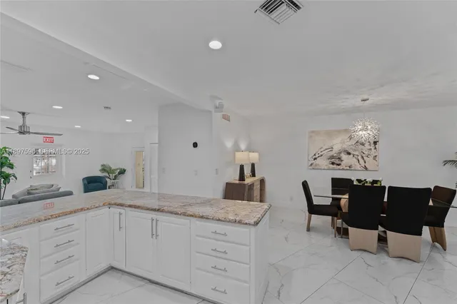 a spacious bathroom with a granite countertop sink and a mirror