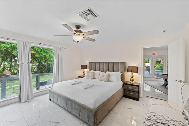 a bedroom with a large bed and a chandelier