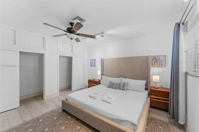 a bedroom with a large bed and a chandelier