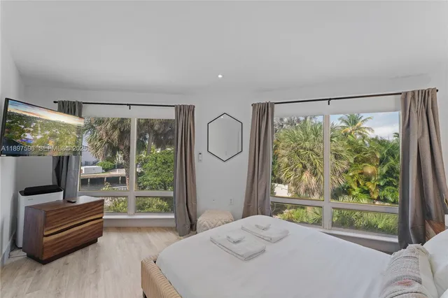 a bedroom with furniture and a flat screen tv