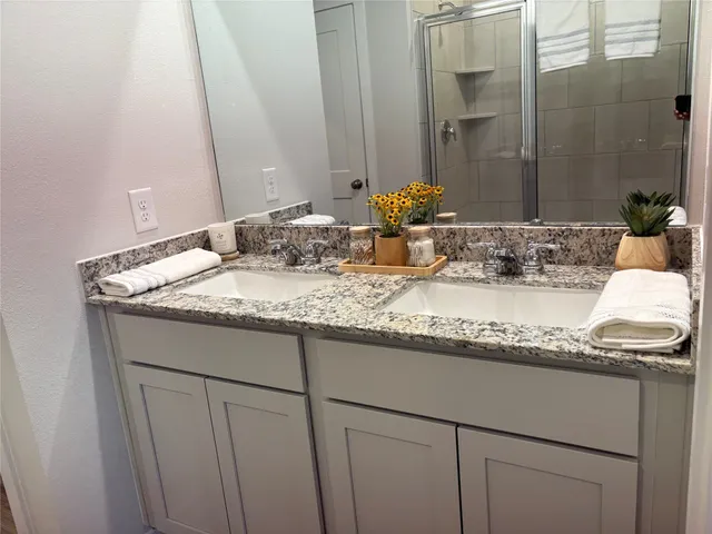 a bathroom with a granite countertop sink and a mirror