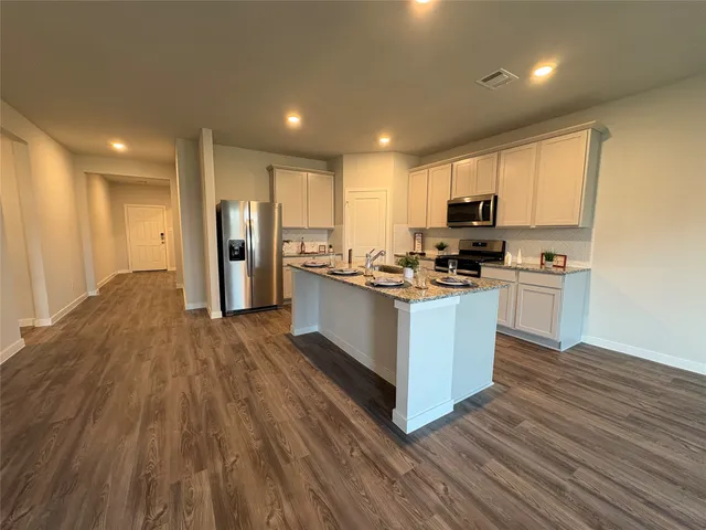 a kitchen with stainless steel appliances a refrigerator and a stove top oven
