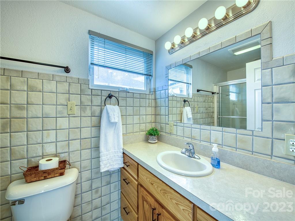 947 North Canton Road Canton, NC 28716 - Photo 19 of 24 a bathroom with a granite countertop sink a toilet and mirror