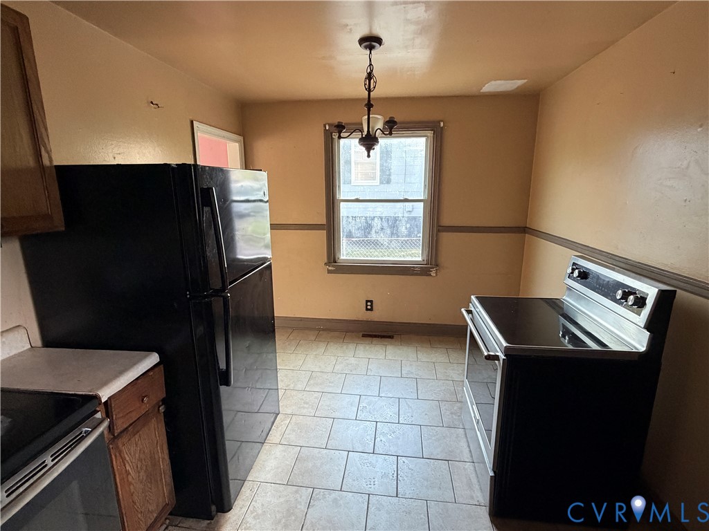 2401 Raleigh Street Hopewell, VA 23860 - Photo 3 of 10 a kitchen with a refrigerator a stove a sink and a window