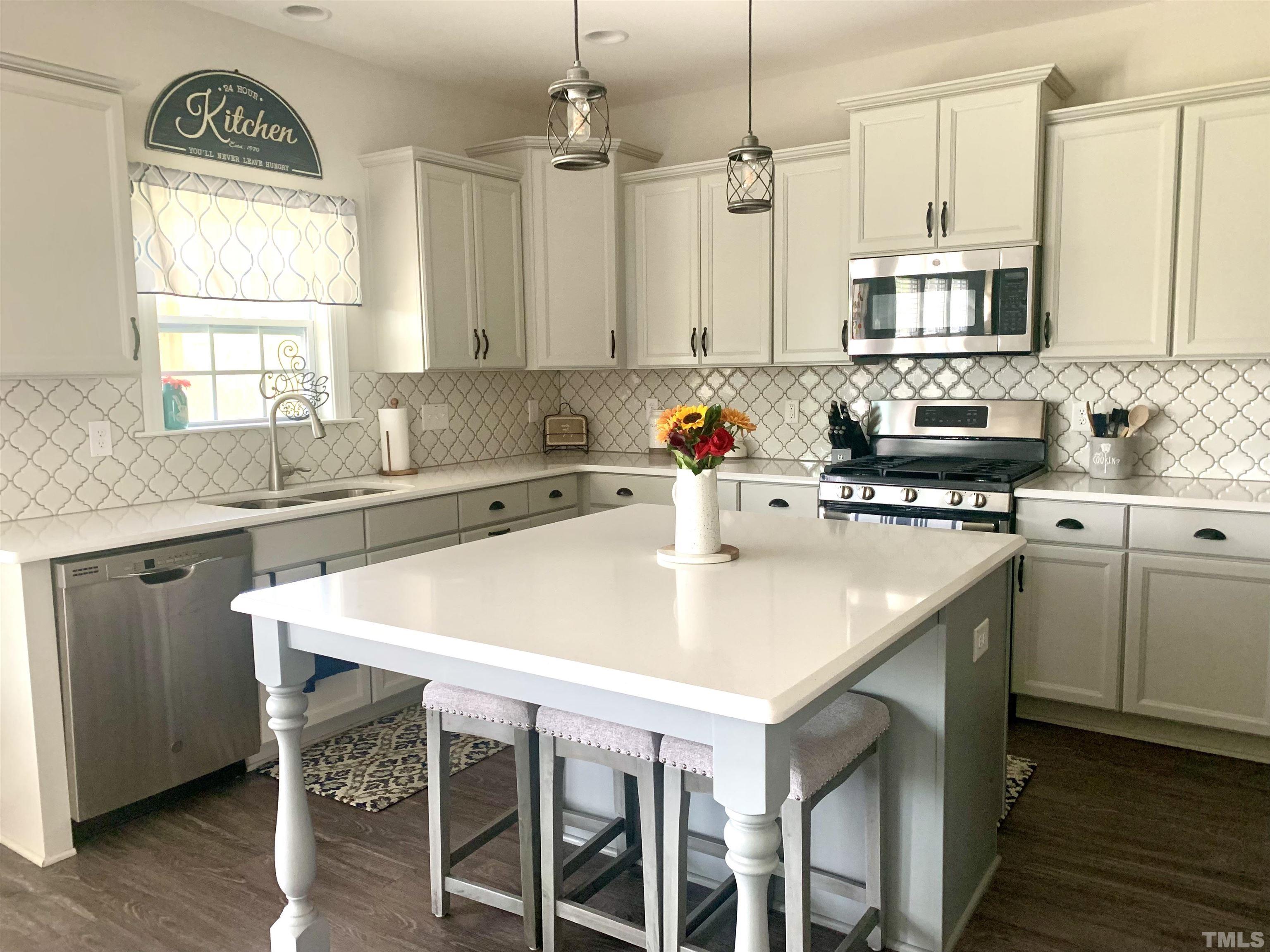 460 Mallard Loop Drive Clayton, NC 27527 - Photo 2 of 24 a kitchen with stainless steel appliances granite countertop a sink a microwave a stove and white cabinets