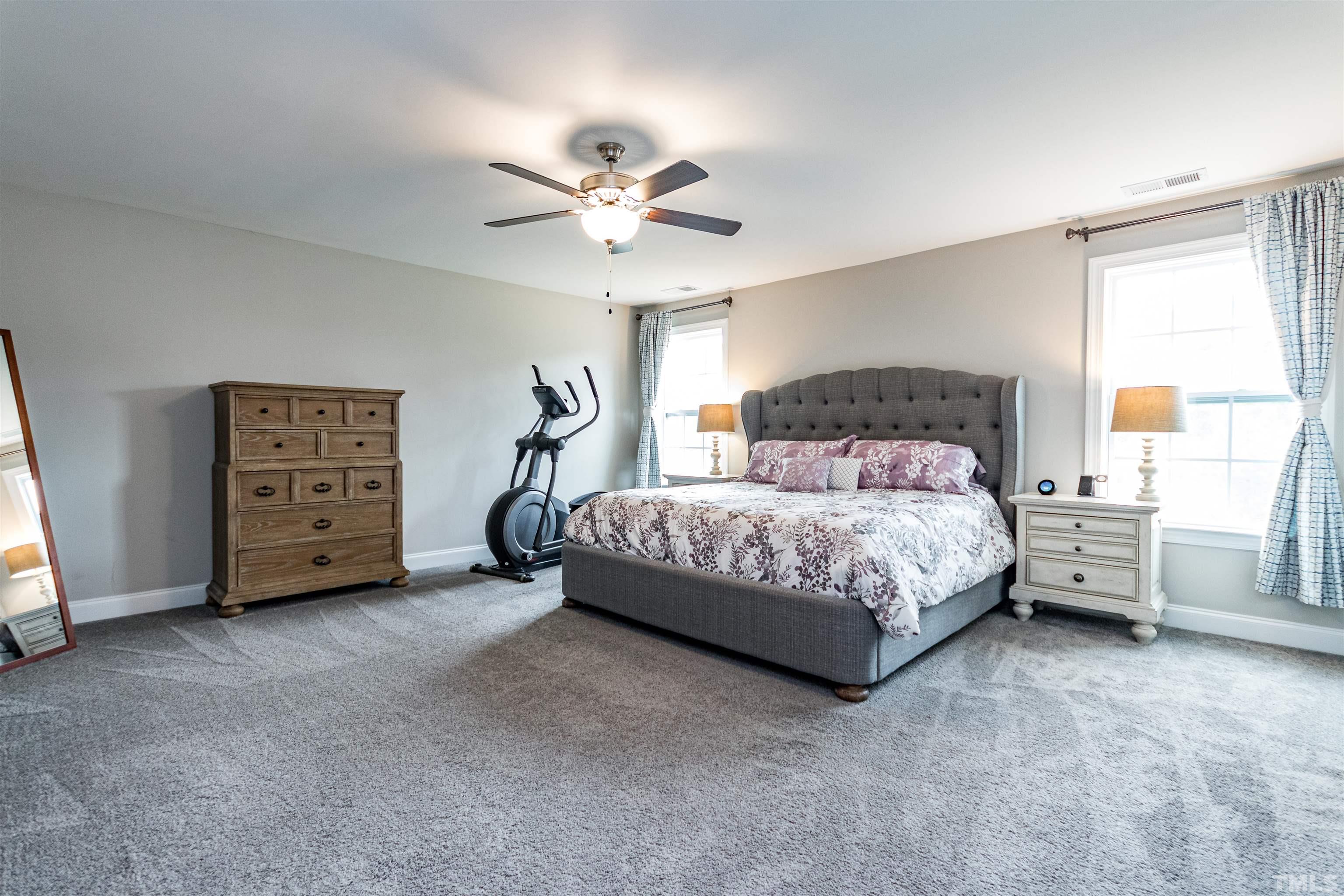 460 Mallard Loop Drive Clayton, NC 27527 - Photo 19 of 24 a bedroom with a bed a chandelier and a couch