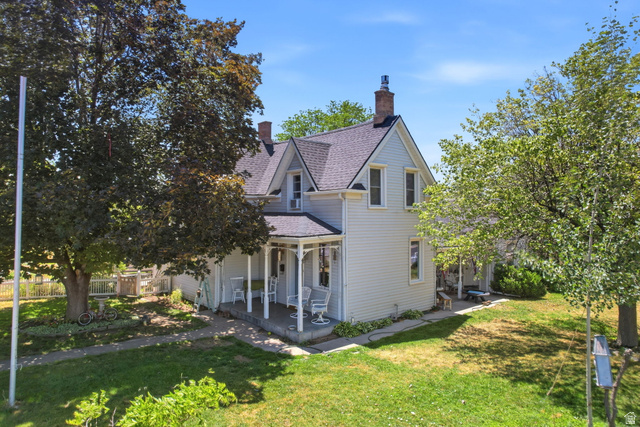 310 South 300 West Payson, UT 84651 - Photo 6 of 42 Light-colored siding home featuring a classic porch, dark roof, and multiple chimneys
