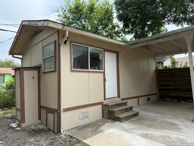 a view of a house with a yard and wooden fence