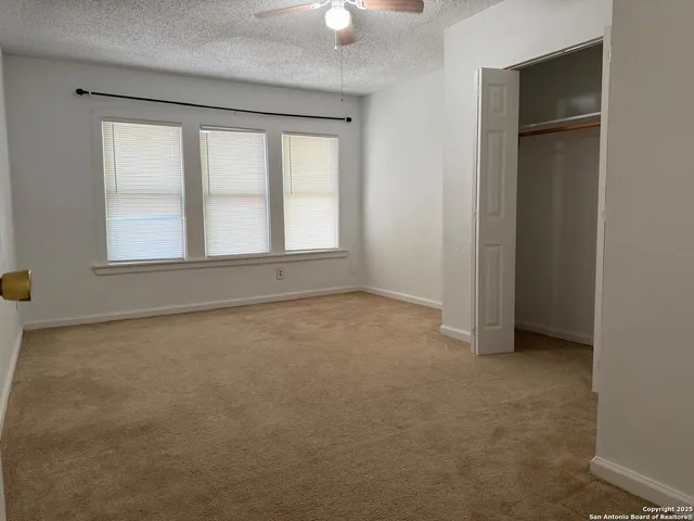 an empty room with windows and closet