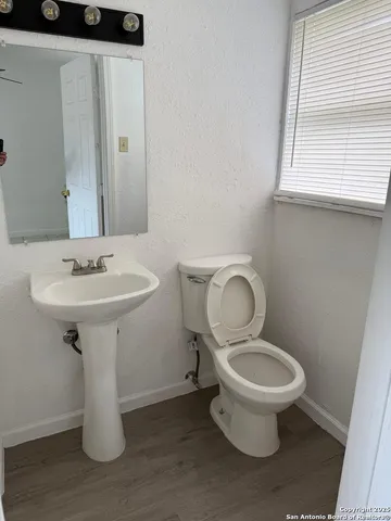 a bathroom with a toilet sink and mirror