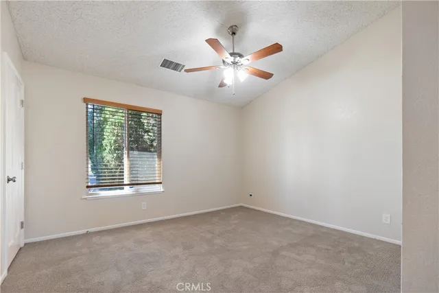 an empty room with windows and fan