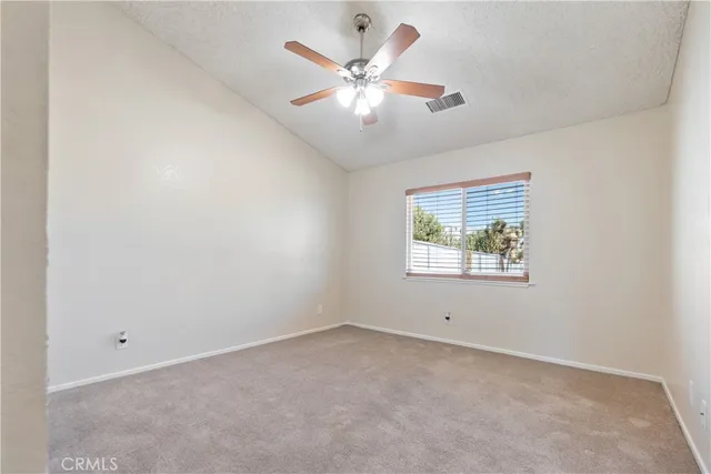 an empty room with a window and a fan