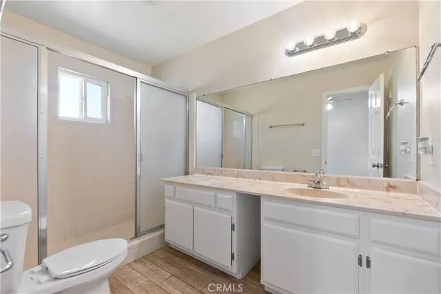 a bathroom with a granite countertop sink toilet a mirror and shower