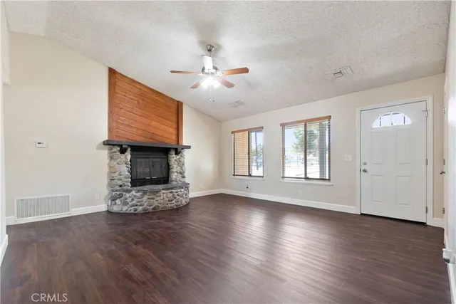 a view of a livingroom with furniture a fireplace and wooden floor