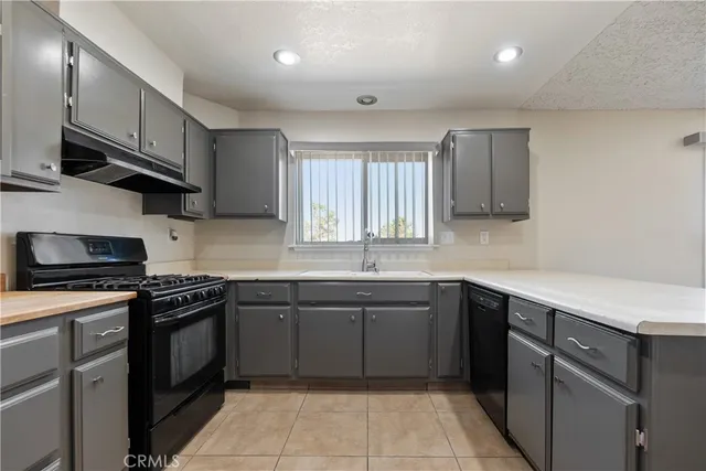 a kitchen with a sink stove top oven and cabinets