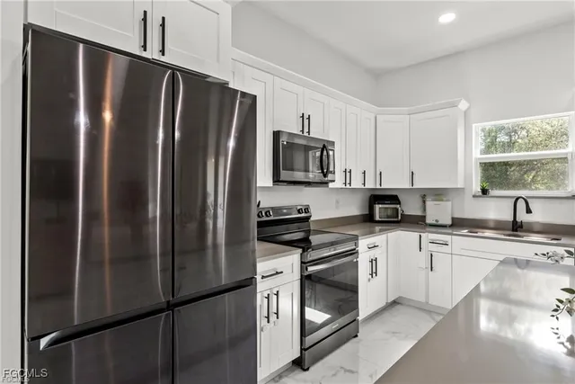 a kitchen with stainless steel appliances a refrigerator sink and microwave