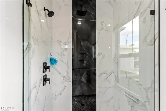 a bathroom with a glass door shower and a sink