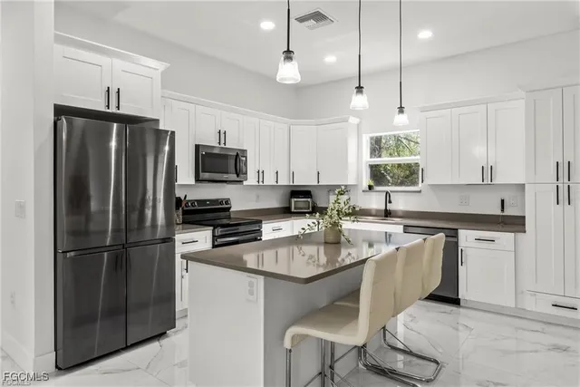 a kitchen with a refrigerator a sink appliances and cabinets