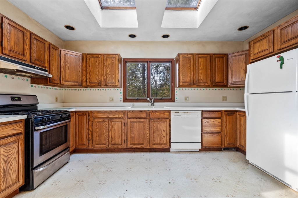 16 2nd Street Saugus, MA 01906 - Photo 15 of 37 a kitchen with granite countertop a stove a sink and a refrigerator