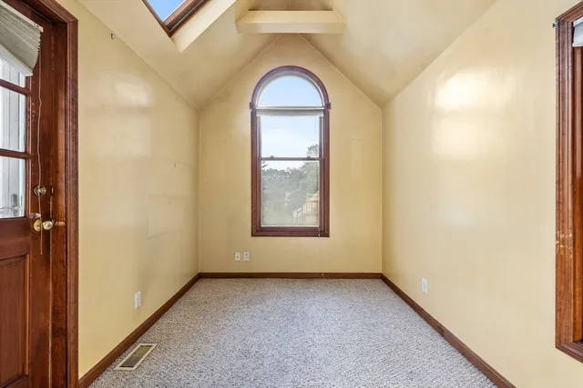 an empty room with window and mirror