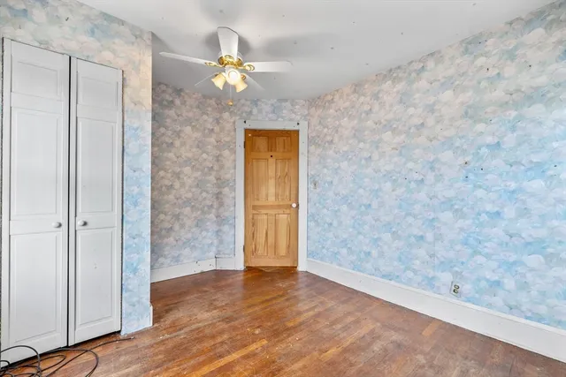 a view of a hallway with wooden floor and chandelier