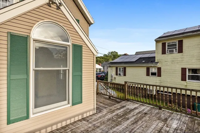 a view of a house with wooden fence next to a yard